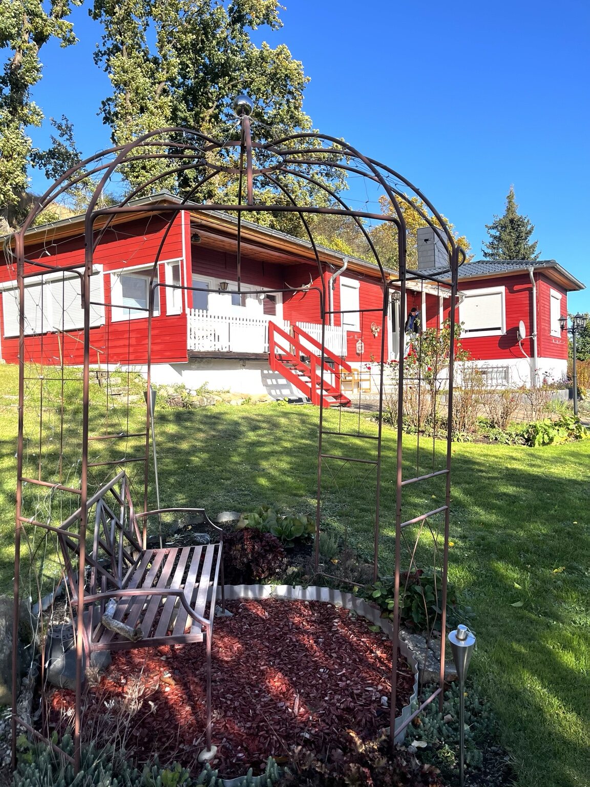 Bungalow mit Garten und Rosenbogen
